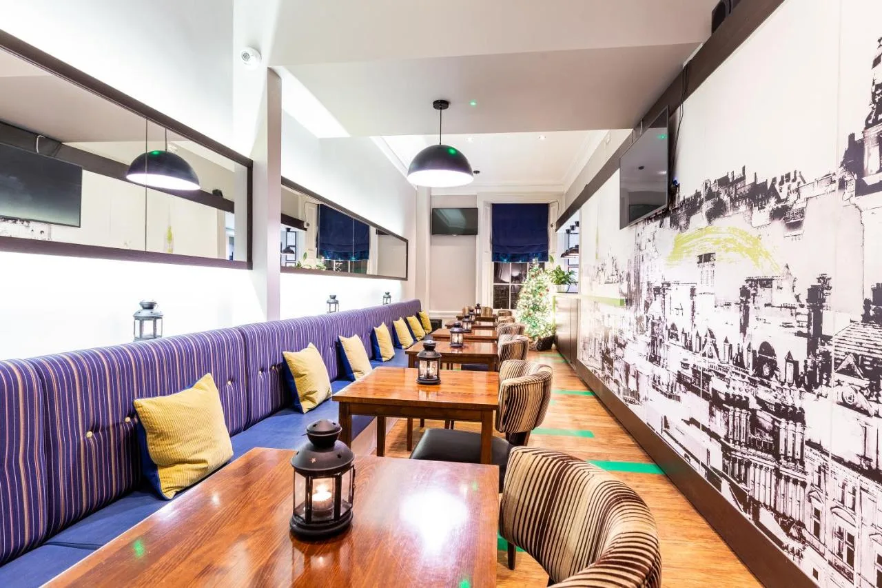 a row of tables and chairs in a restaurant at Cairn Hotel & Apartments in Edinburgh