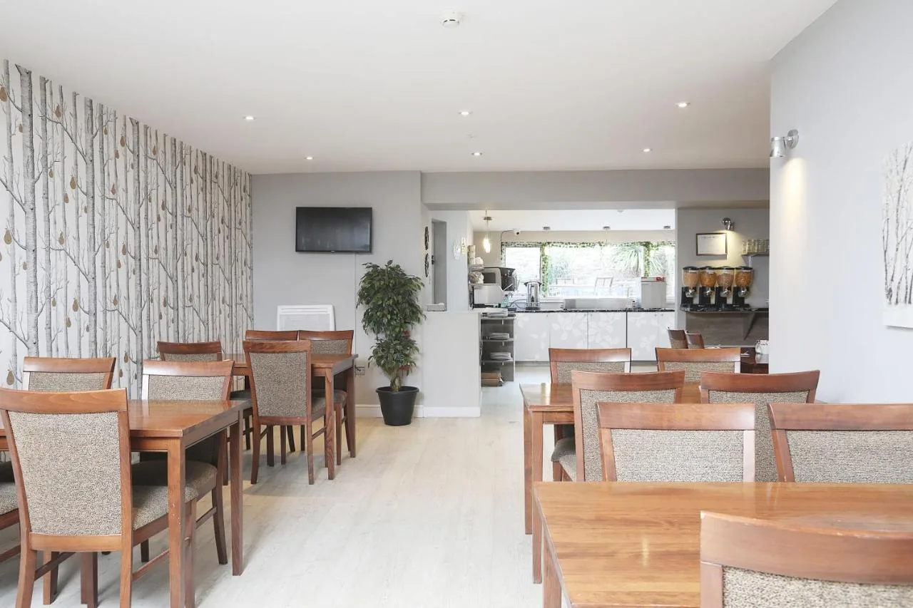 a dining room filled with wooden tables and chairs at Cairn Hotel & Apartments in Edinburgh