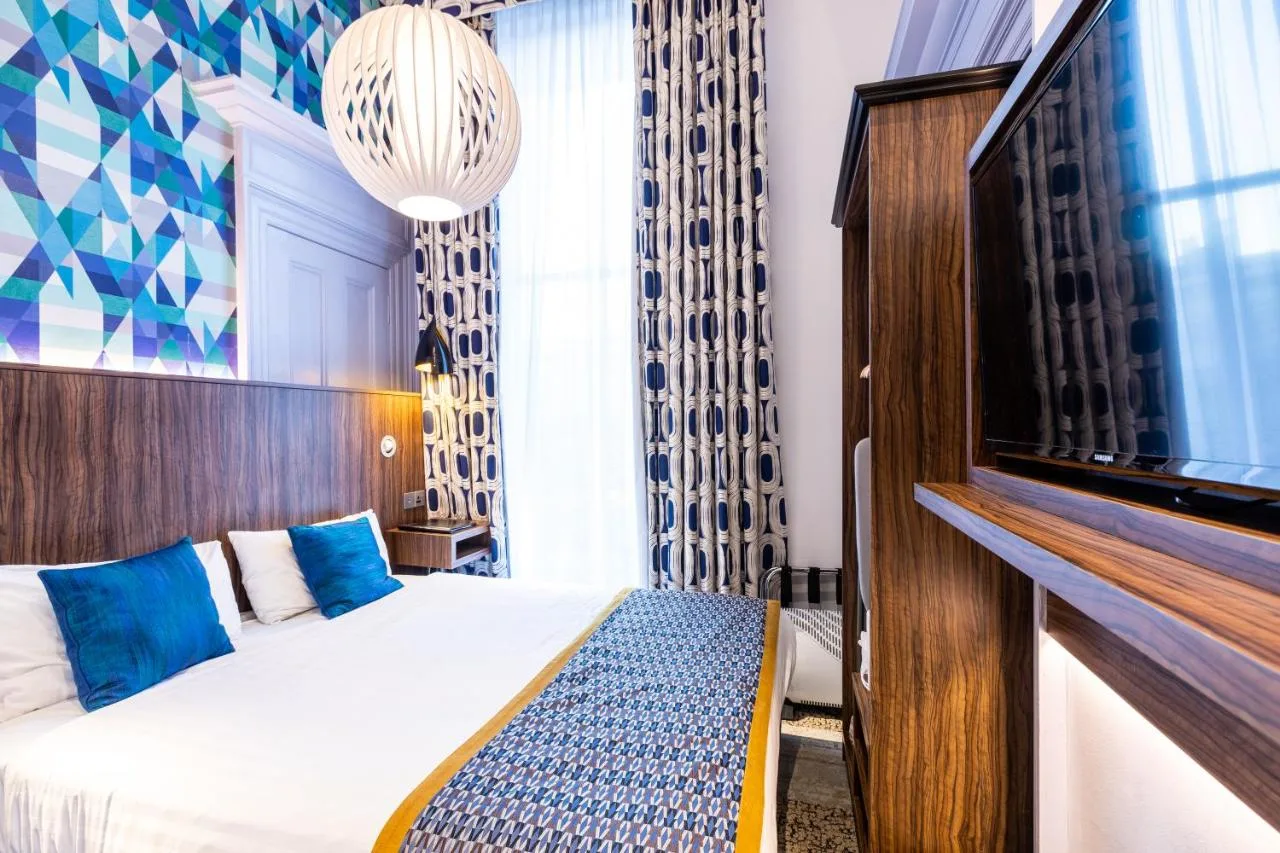 a hotel room with a bed and a tv at Cairn Hotel & Apartments in Edinburgh